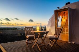 una mesa y sillas en una terraza con yurta en Eslanzarote Luxurious Eco Dome Experience, en Teguise