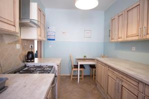 a kitchen with wooden cabinets and a table in it at Apartament Bystry Centrum APARTZAKOP in Zakopane