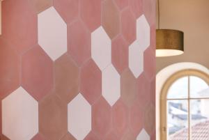 1 dormitorio con pared hexagonal en Goldengel Design - Suiten im historischen Ortskern von Kaltern, en Caldaro