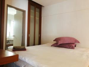 a bedroom with a large white bed with a mirror at Peninsula Residence All Suite Hotel in Kuala Lumpur