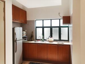 a kitchen with wooden cabinets and a window in it at Peninsula Residence All Suite Hotel in Kuala Lumpur