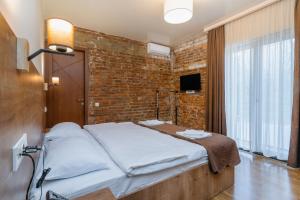 a bed in a room with a brick wall at Hotel Green Town in Kutaisi