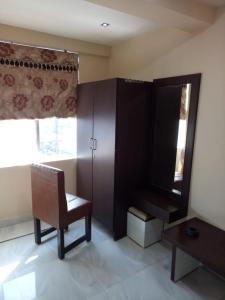 Vamoose Akshat Chindwara في Chhindwāra: غرفة معيشة مع كرسي ومرآة