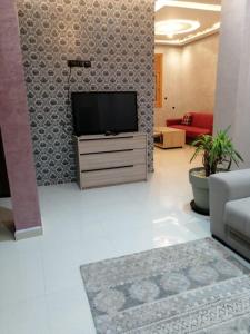 a living room with a television on a dresser at Joli appartement Casablanca ain sebaa in Casablanca