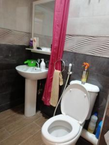 a bathroom with a white toilet and a sink at Joli appartement Casablanca ain sebaa in Casablanca