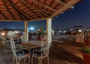 a wooden table and chairs on a roof at night at Jaipur Inn in Jaipur