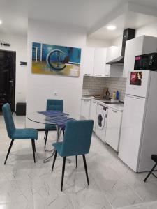a kitchen with a table and chairs and a washing machine at Lovely Apartment in City Center in Batumi