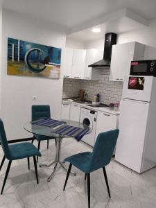 a kitchen with a table and chairs and a refrigerator at Lovely Apartment in City Center in Batumi