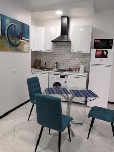 a kitchen with a table and chairs and a stove at Lovely Apartment in City Center in Batumi