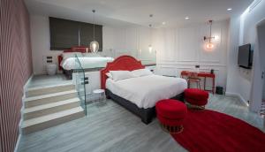 a bedroom with two beds and a red headboard at HOLM Boutique & SPA - IK Collection in St. Julianʼs