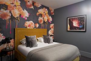 ein Schlafzimmer mit einem Bett und Blumen an der Wand in der Unterkunft Malmaison Reading in Reading