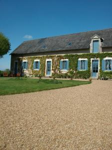 une maison en pierre avec du lierre sur son côté dans l'établissement La Cochetière, à Cheviré-le-Rouge