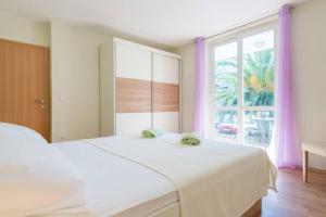 um quarto com uma grande cama branca e uma janela em Apartment Magnolia em Dubrovnik