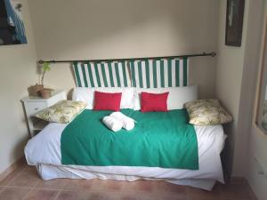 a green and white bed with red pillows on it at VUT Casa Helen in Avila