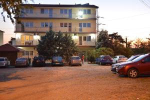ein Parkplatz mit Autos vor einem Gebäude in der Unterkunft Casa Vienna in Eforie Nord