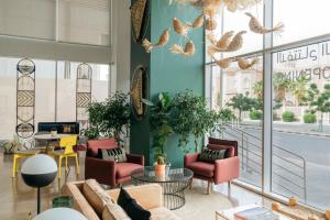 a lobby with chairs and tables and windows at Shada Hotel Shatea in Jeddah