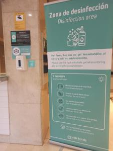 a sign for a disinfection sign in a building at Hotel Alda Estación Pontevedra in Pontevedra