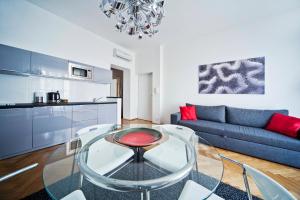 a living room with a glass table and a blue couch at 4Seasons﻿ Apartments Cracow in Kraków