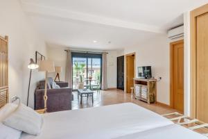 a bedroom with a bed and a living room at Pierre & Vacances Resort Fuerteventura OrigoMare in Lajares +77 photos