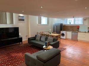 a living room with a couch and a tv and a kitchen at Charter House School Serviced Apartments - Hull Serviced Apartments HSA in Hull