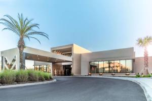 a large building with palm trees in front of it at Magic Village Views Trademark Collection by Wyndham in Orlando