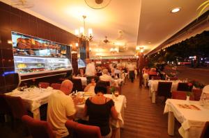 Eine Gruppe von Menschen sitzt an Tischen in einem Restaurant in der Unterkunft Diva Hotel in Marmaris
