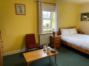 una camera da letto con un letto, un tavolo e una sedia di An Stór Townhouse a Midleton