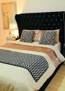 a bed with a black and white blanket and pillows at Luxury Penthouse Suite, Cantonments-Labone in Accra