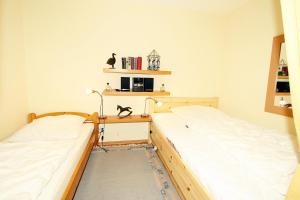 two twin beds in a bedroom with a desk at Ferienpark G06-012 Ferienpark in Heiligenhafen
