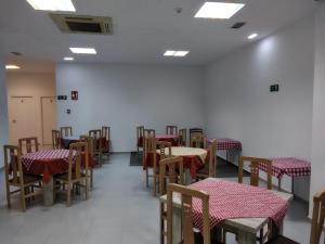 a dining room with tables and chairs with red and white at Hostal San Jorge in Zaragoza