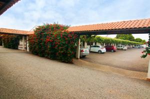 a building with cars parked in a parking lot at Mediterrâneo Park Hotel in Três Lagoas