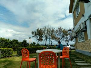 a table with four chairs and a person sitting at it at 晴川樹 in Taitung City