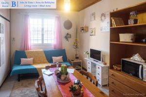 uma pequena sala de estar com uma mesa e um sofá em Casa dos Guerra em Ponta Delgada