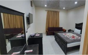 a hotel room with a bed and a living room at Family Guest House in Garden Town in Lahore