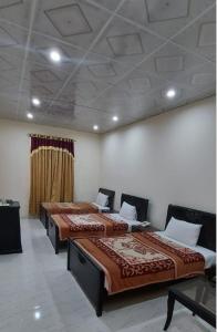 a row of three beds in a room at Family Guest House in Garden Town in Lahore