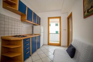 a kitchen with blue cabinets and a couch in a room at Apartments Grulović in Srima +27 photos