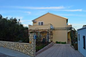 a house with a stone fence in front of it at Apartments Vilim Tisno in Tisno