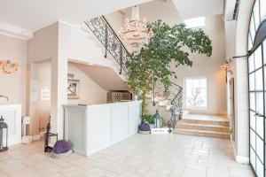 a living room with a staircase and a chandelier at Riviera Resort Airport Modlin in Olszewnica Nowa