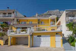 a yellow apartment building with a balcony at Apartments Antonio in Baška Voda