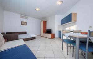 a room with a bed and a table and chairs at Apartments Jelena in Barbat na Rabu