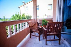 two chairs sitting on a balcony with a view at Apartments Jasko 2895 in Barbat na Rabu