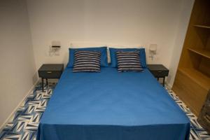 Una cama azul con dos almohadas encima. en Blu Marina, en Vietri