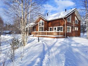 a wooden house in the snow with a snow covered yard at Saimaa Lakeside in Ruokolahti