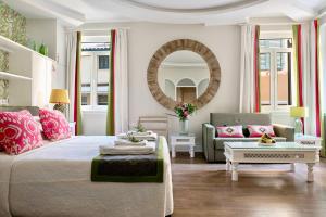 a living room with a bed and a mirror at Kouloura Liston Suite in Corfu