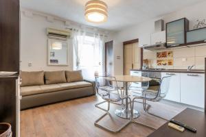 a living room with a couch and a table and chairs at Old Town Charm Apartment in Dubrovnik
