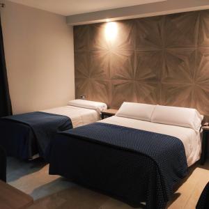 a room with two beds and a wall at Hotel Ciudad de Navalcarnero in Navalcarnero