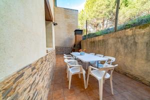 ein weißer Tisch und Stühle auf einer Terrasse in der Unterkunft El Mirador del Alberche III in Navaluenga