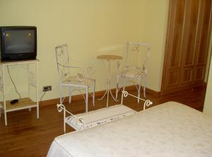 サン・レオナルド・デ・ヤグエにあるManrique de Laraのベッドルーム1室(椅子2脚、テーブル、テレビ付)