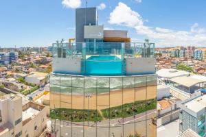 a building with a swimming pool on top of it at Hotel Água de Coco in Maceió