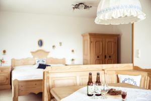 a room with two beds and two bottles of wine on a table at Frühstückspension Windlegern in Neukirchen